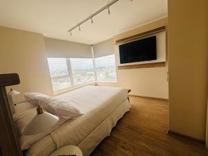 a bedroom with a large bed and a large window at Apart Hotel RCB in Chillán +14 photos