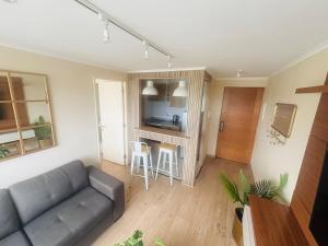 a living room with a couch and a kitchen at Apart Hotel RCB in Chillán