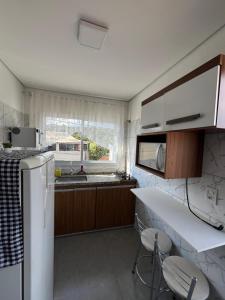 a kitchen with a white refrigerator and a sink at Casa Lua in Brumadinho