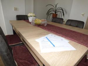 a long wooden table with a pen on top of it at Pogácsás Apartman in Tokaj