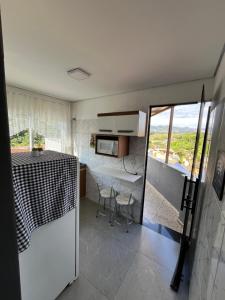 a small kitchen with a table and a microwave at Casa Lua in Brumadinho +11 photos