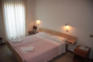 a bedroom with a large bed with towels on it at Hotel Orchidea Rimini in Rimini
