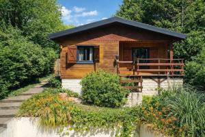a small wooden cabin with a porch and stairs to it at - Chalet Cosy - Pleine nature in Lagnieu