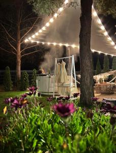 a man sitting in a chair under a tent at night at Sosenkowe Apartamenty Balia & Jacuzzi in Kuźnica Głogowska