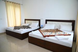 two beds sitting next to each other in a room at Ayushman hotel in Uttarkāshi +6 photos
