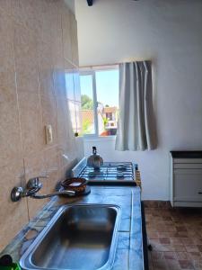 a kitchen with a sink and a stove at Bruna de Mar in Mar de Ajó