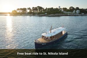 a boat in the water on a river at Isabella Island Miramare Suites & Villas, Valamar Collection in Poreč