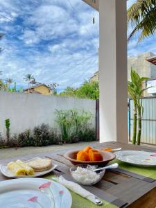 a table with plates of food and a bowl of fruit at Coco Bliss - Ahangama in Ahangama