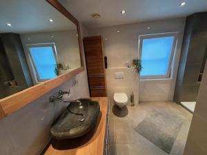 a large bathroom with a sink and a toilet at Gasthuys Rooy in Stramproy
