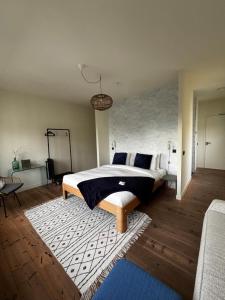 a bedroom with a large bed and a rug at Bird Deventer in Deventer