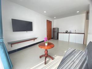 a living room with a table and a tv on the wall at HomeStore Apartment in Siem Reap
