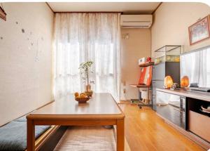 a living room with a table in front of a window at TOMO HOUSE in Taketoyo