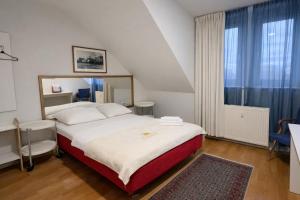 a bedroom with a large bed and a large window at Sonne Hotel in Herne
