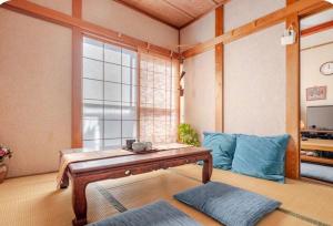 a living room with a table and a blue couch at TOMO HOUSE in Taketoyo