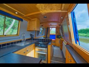 a kitchen with a sink and a stove in it at Dylan, 43ft Narrowboat with Garden in North Newton +10 photos