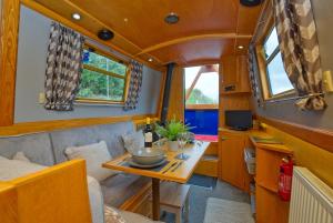 a dining room and kitchen in a tiny house at Dylan, 43ft Narrowboat with Garden in North Newton
