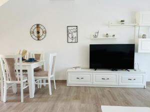 a living room with a white entertainment center with a flat screen tv at Valamar Deluxe Beachfront Villa in Draç