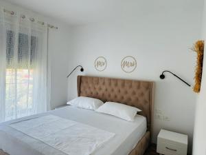 a bedroom with a bed with white sheets and a window at Valamar Deluxe Beachfront Villa in Draç