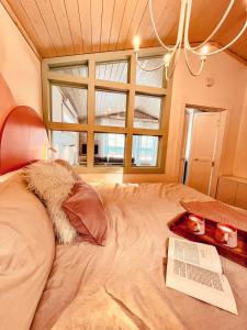 a bedroom with a bed with a book and a window at Couette et Marées - Maisonnette in Sainte-Luce-sur-Mer