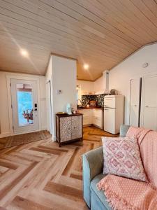 a living room with a couch and a kitchen at Couette et Marées - Maisonnette in Sainte-Luce-sur-Mer
