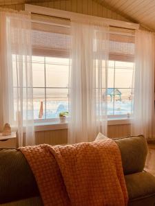 a living room with a couch in front of a window at Couette et Marées - Maisonnette in Sainte-Luce-sur-Mer