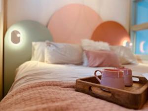 a bed with a wooden tray on top of it at Couette et Marées - Maisonnette in Sainte-Luce-sur-Mer +16 photos