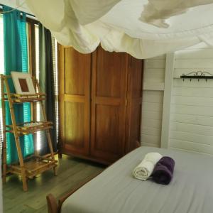 a bedroom with a bed with two towels on it at Gîte 1001 Nuits - SINBAD in Bouillante