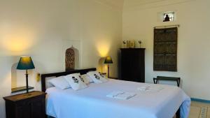 a bedroom with a large bed with white sheets and pillows at Mosaics Guest House in Jaipur