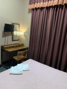 a hotel room with a bed and a desk and a mirror at Four Stars Hotel in London