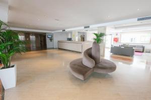 a lobby with a chair in the middle of a building at Port Azafata Valencia in Manises