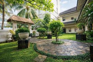 a courtyard of a building with trees and a stone path at The Mirah Hotel Bogor in Bogor