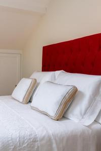 a white bed with a red headboard and two pillows at Metro Loft in Póvoa de Varzim