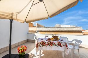a table and chairs on a balcony with an umbrella at Paco House in Avola