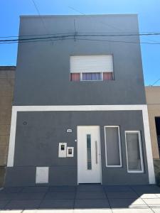 a building with a white door and a window at El Nido FM in Concepción del Uruguay