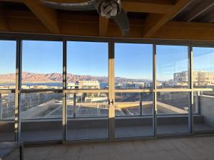 an empty building with glass windows and mountains in the background at דירה 9 in Eilat
