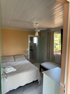 a bedroom with a white bed and a window at Pousada Cantinho da Tia Sandra in São Francisco do Sul +99 photos