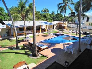 an aerial view of a resort with a pool and palm trees at Pousada Paraiso da Barra in Barra de Santo Antônio +18 photos