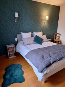 a large bed in a bedroom with a green wall at Gîte du Craon de Ludes in Ludes
