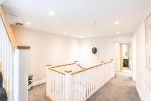 a white staircase in a home with white walls at Northern Hideaways, Brown Bear House in Berwick-Upon-Tweed