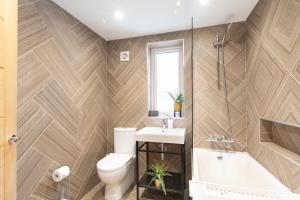 a bathroom with a toilet and a sink and a tub at Northern Hideaways, Brown Bear House in Berwick-Upon-Tweed
