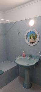 a bathroom with a sink and a tub and a mirror at SwordFish Cliff Apartment in Peniche