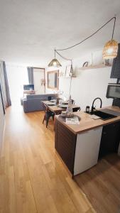 a kitchen and living room with a table and a couch at Charmant Appartement Les temples du Soleil in Font-Romeu-Odeillo-Via