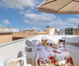 a table and chairs on a balcony with an umbrella at Paco House in Avola