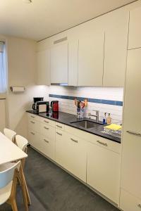 a kitchen with white cabinets and a sink at Apartment Haus Altein Apartment Nr- 4 by Interhome in Davos +27 photos
