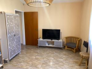 a living room with a flat screen tv and a chair at Casa Ayacucho in Alta Gracia +11 photos