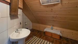 a bathroom with a white sink and a wooden wall at Eskapada in Stronie Śląskie +73 photos