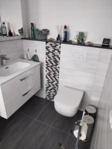 a bathroom with a white toilet and a sink at FeWo Waldblick in Goslar +10 photos