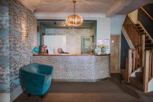 a lobby with a counter and a blue chair at The White Rock Hotel in Hastings