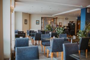 a dining room with tables and chairs and a room with at The White Rock Hotel in Hastings