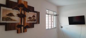 a room with pictures on the wall and a television at Casa duplex para lazer in Paulista